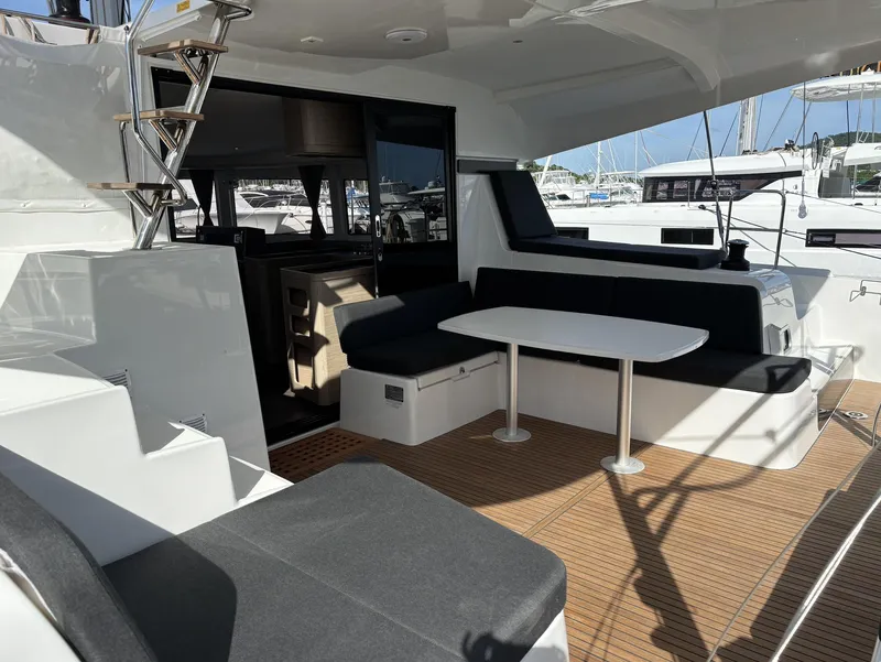 Slide: The Image of 2025 Lagoon 42 yacht deck with seating and table, featuring modern design and wood flooring. - 21