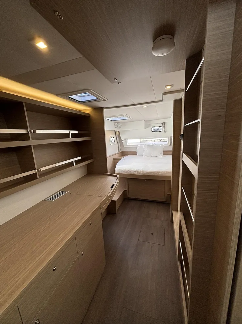 Slide: The Image of Luxurious interior of 2025 Lagoon 42 catamaran with modern wood finishes and spacious bedroom. - 23