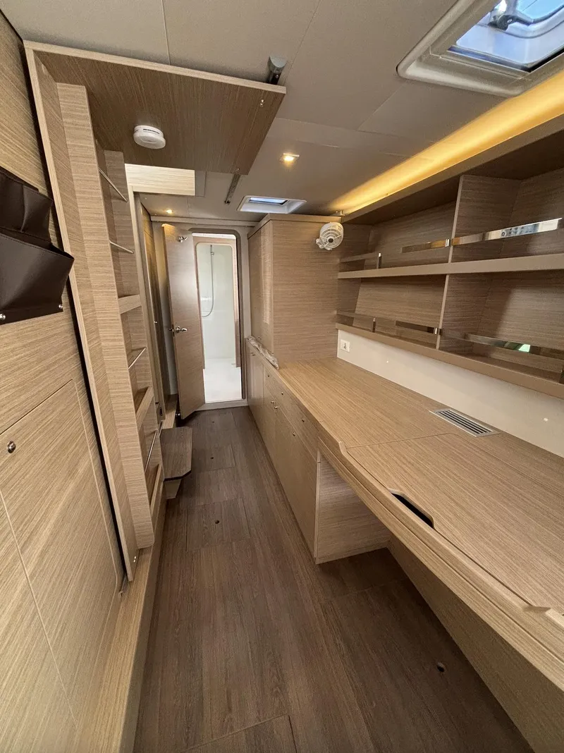 Slide: The Image of Interior of 2025 Lagoon 42 catamaran with modern wood finish and ample storage. - 26