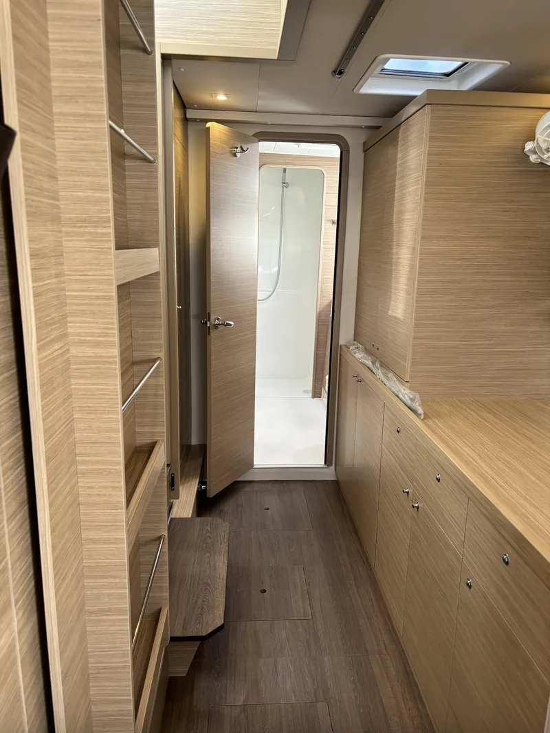 Slide: The Image of Interior of 2025 Lagoon 42 yacht, featuring modern wood cabinetry and sleek design. - 27