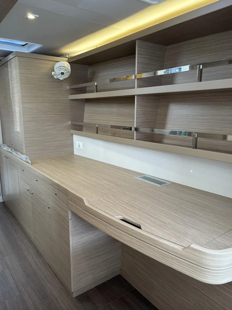 Slide: The Image of Modern interior of 2025 Lagoon 42 yacht with sleek wooden cabinetry and shelving. - 28