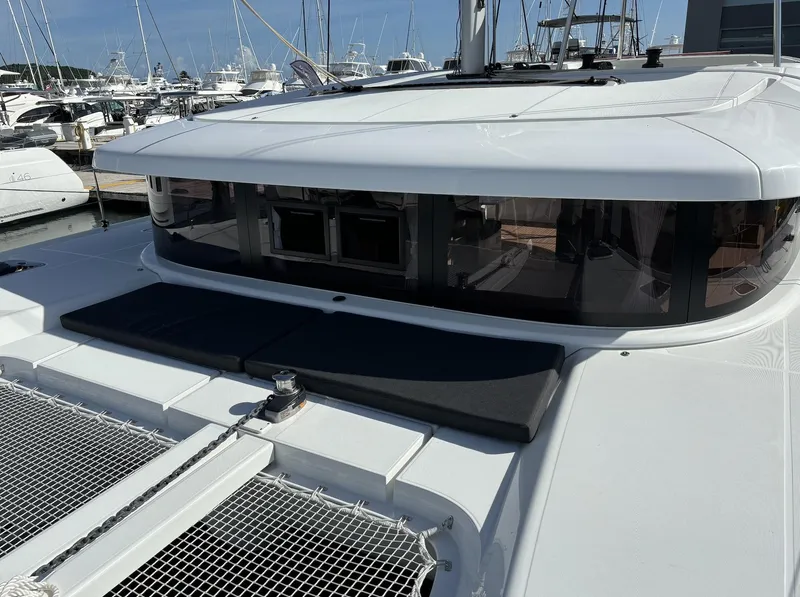 Slide: The Image of 2025 Lagoon 42 catamaran docked at marina, showcasing sleek design and spacious deck. - 4
