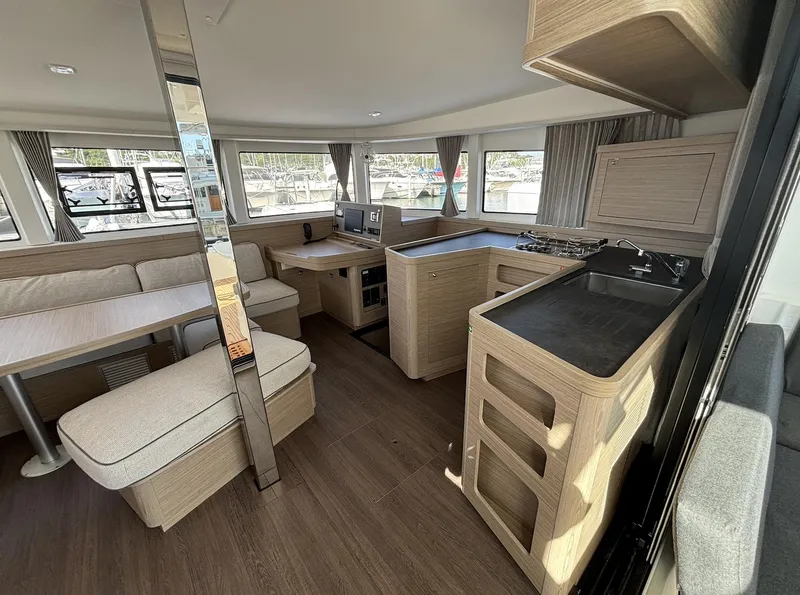 Slide: The Image of Interior of 2025 Lagoon 42 catamaran with modern kitchen and seating area. - 9