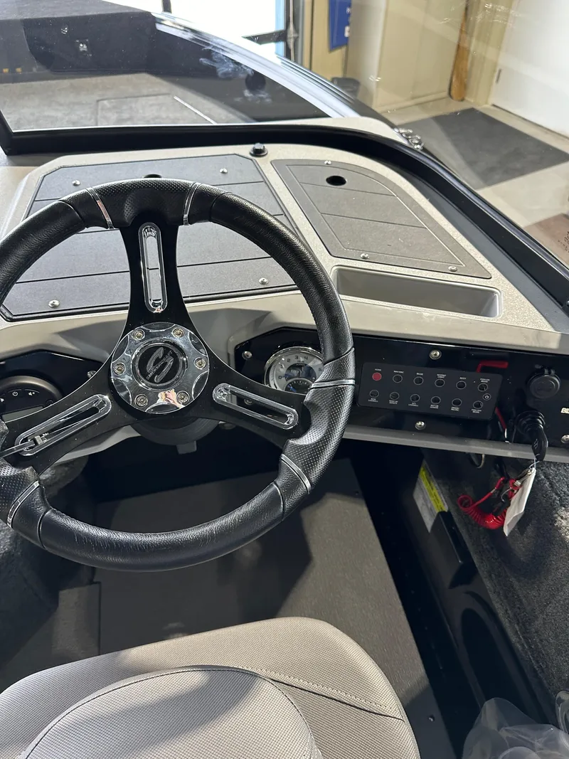 Slide: The Image of 2025 Smoker Craft Adventurer 188 DC boat dashboard with steering wheel and control panel. - 6