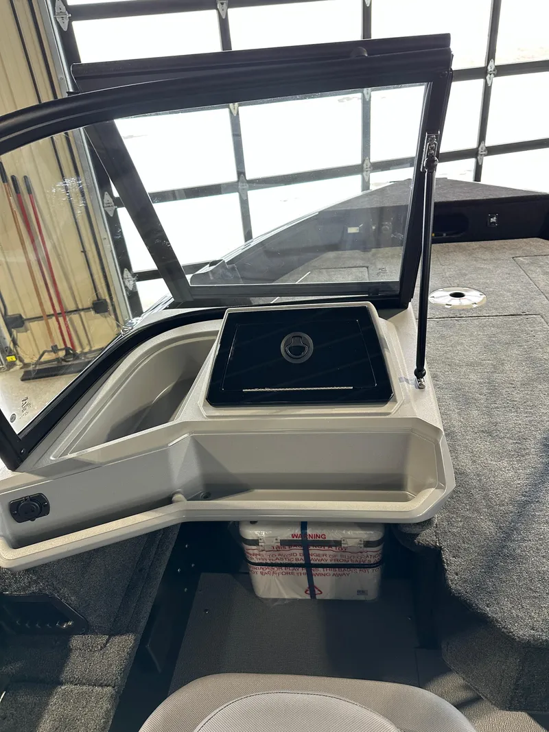 Slide: The Image of 2025 Smoker Craft Adventurer 188 DC boat interior with open windshield and storage compartment. - 9