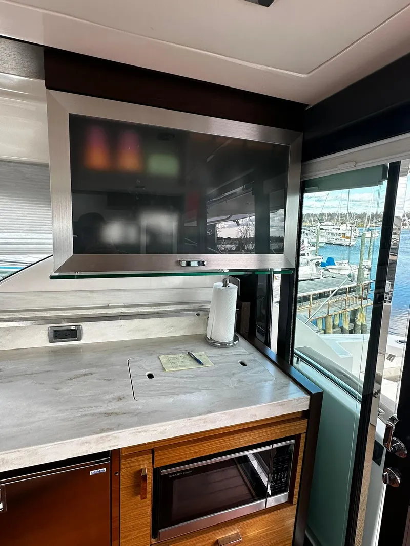 Slide: The Image of Interior of 2016 Tiara Yachts 49 COUPE with modern kitchen and marina view. - 10