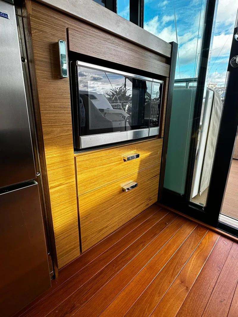 Slide: The Image of 2016 Tiara Yachts 49 COUPE interior with modern wood cabinetry and sleek appliances. - 12