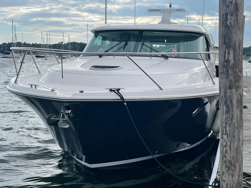 Slide: The Image of 2016 Tiara Yachts 49 COUPE docked on a calm waterfront. - 2