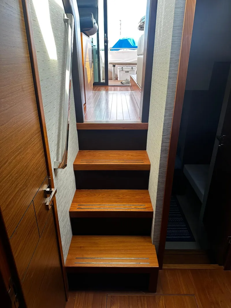 Slide: The Image of Staircase inside 2016 Tiara Yachts 49 COUPE, leading to upper deck with wooden flooring. - 23