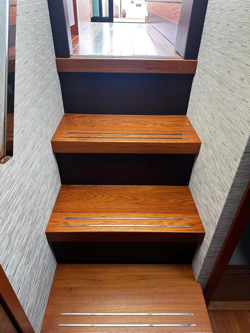Slide: The Image of Wooden stairs inside 2016 Tiara Yachts 49 COUPE, leading to upper deck. - 25