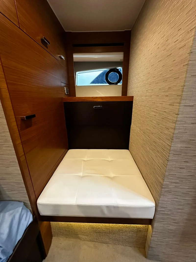 Slide: The Image of 2016 Tiara Yachts 49 COUPE interior cabin with wooden finish and cushioned seating. - 42