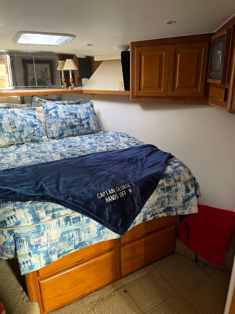 Slide: The Image of Cozy bedroom in 1996 Viking 47 Convertible yacht with nautical-themed bedding. - 11