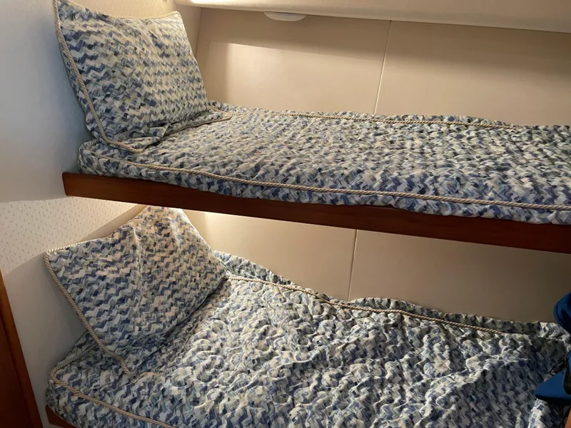 Slide: The Image of Bunk beds with patterned bedding in a 1996 Viking 47 Convertible yacht cabin. - 13