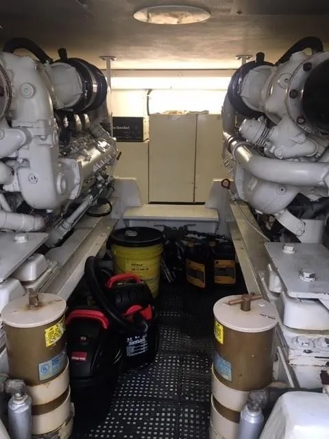 Slide: The Image of Engine room of 1996 Viking 47 Convertible yacht, featuring dual engines and maintenance equipment. - 32