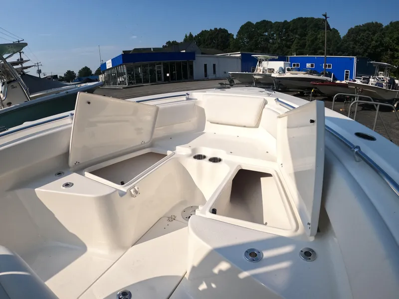 Slide: The Image of 2025 Key West 239 FS boat with open storage compartments at a marina. - 17