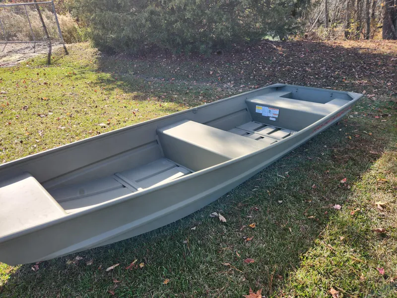 Slide: The Image of 2025 Tracker Grizzly 1436 Utility boat on grass, sunny day. - 2