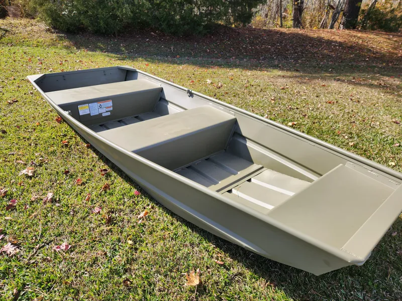 Slide: The Image of 2025 Tracker Grizzly 1236 Utility boat on grass, showcasing its sturdy design. - 2