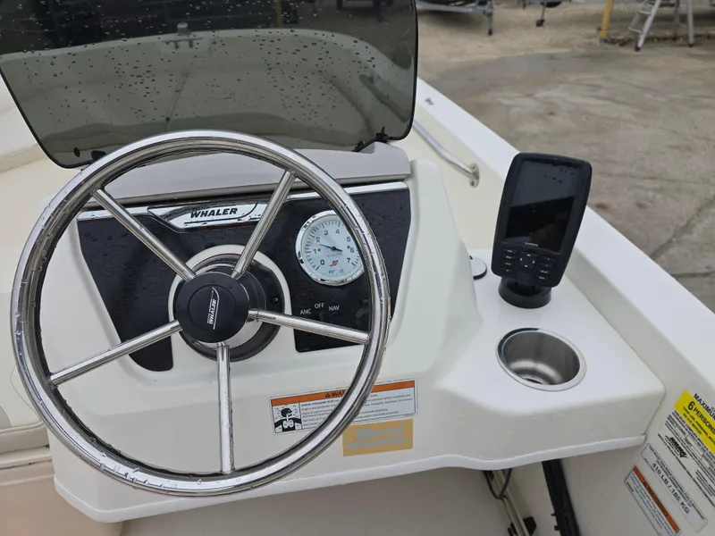 Slide: The Image of 2022 Boston Whaler 160 Super Sport dashboard with steering wheel and navigation display. - 15