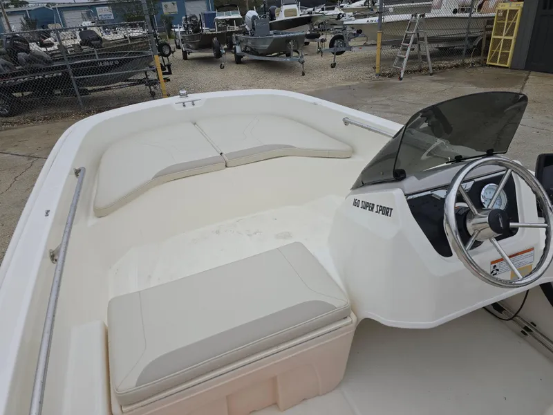 Slide: The Image of 2022 Boston Whaler 160 Super Sport boat interior with steering wheel and seating. - 16