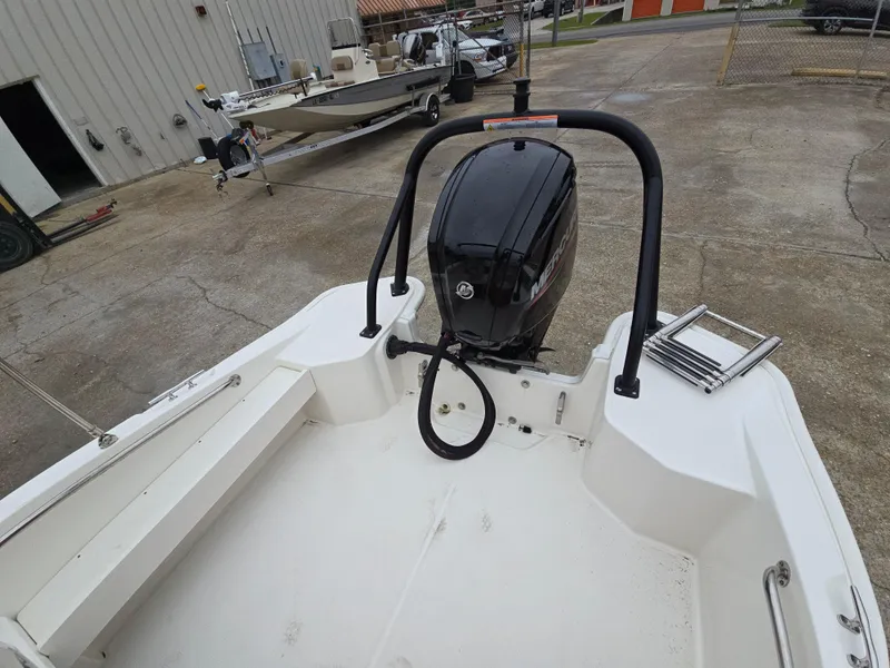 Slide: The Image of 2022 Boston Whaler 160 Super Sport boat with outboard motor in a parking area. - 17
