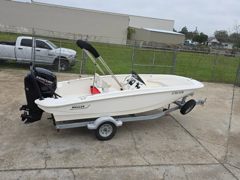 Slide: The Image of 2022 Boston Whaler 160 Super Sport boat on trailer, parked outdoors. - 4