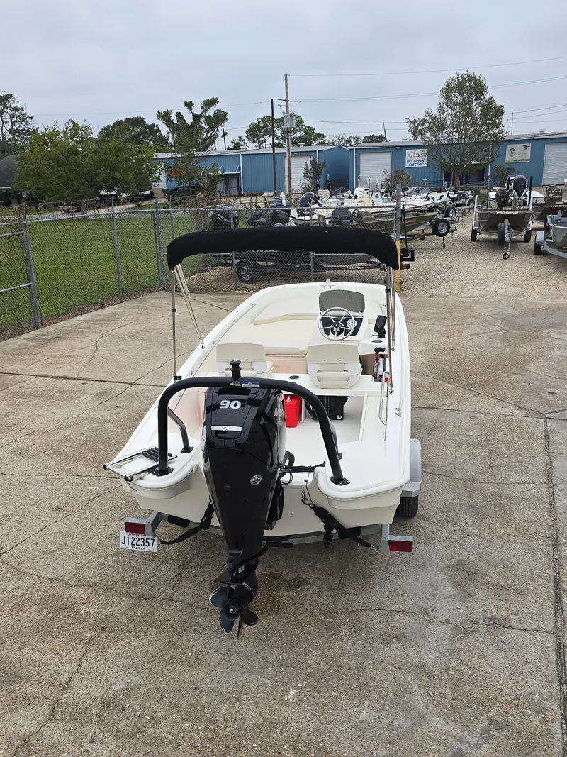 Slide: The Image of 2022 Boston Whaler 160 Super Sport boat with outboard motor in a storage yard. - 6