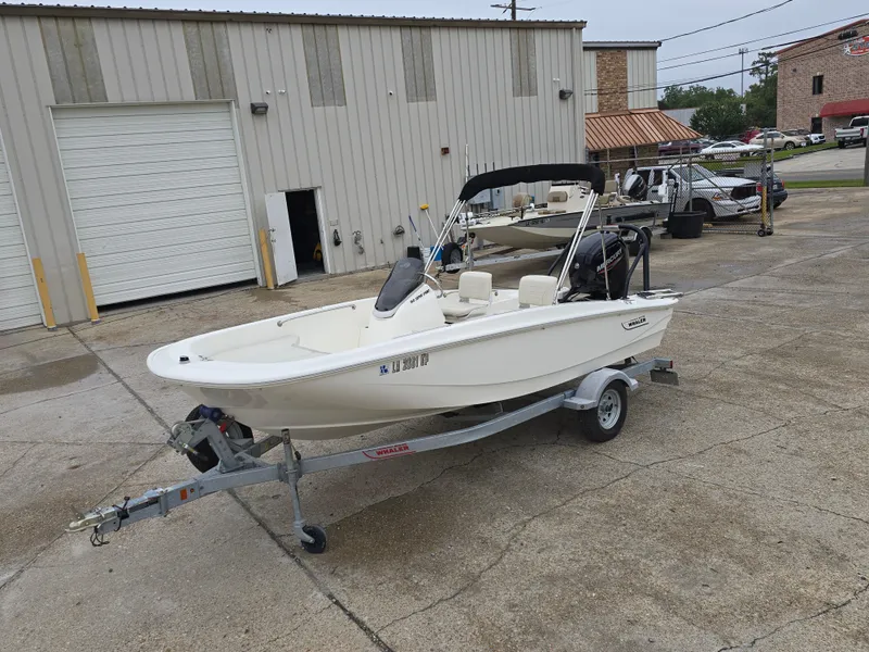 Slide: The Image of 2022 Boston Whaler 160 Super Sport boat on trailer in industrial area. - 9