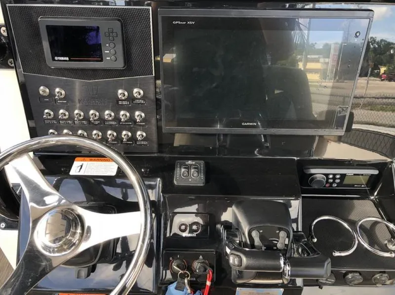 Slide: The Image of 2018 Wellcraft 302 Fisherman dashboard with steering wheel, controls, and Garmin display. - 11