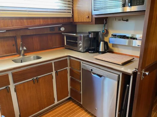 Slide: The Image of 1973 Hatteras Motor Yacht kitchen with wood cabinets, modern appliances, and stainless steel sink. - 11