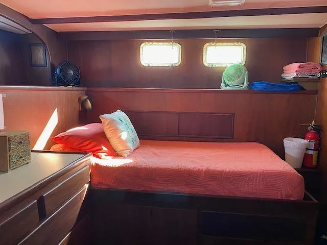 Slide: The Image of Cozy bedroom in 1973 Hatteras Motor Yacht with wood paneling and porthole windows. - 14