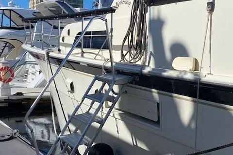 Slide: The Image of 1973 Hatteras Motor Yacht docked with boarding ladder and nautical equipment. - 2