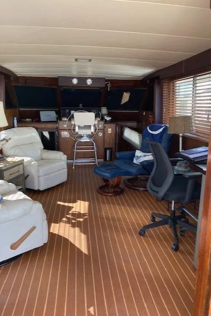 Slide: The Image of Interior of a 1973 Hatteras Motor Yacht with comfortable seating and wooden flooring. - 22