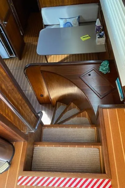 Slide: The Image of Interior of a 1973 Hatteras Motor Yacht with wooden stairs and dining area. - 24