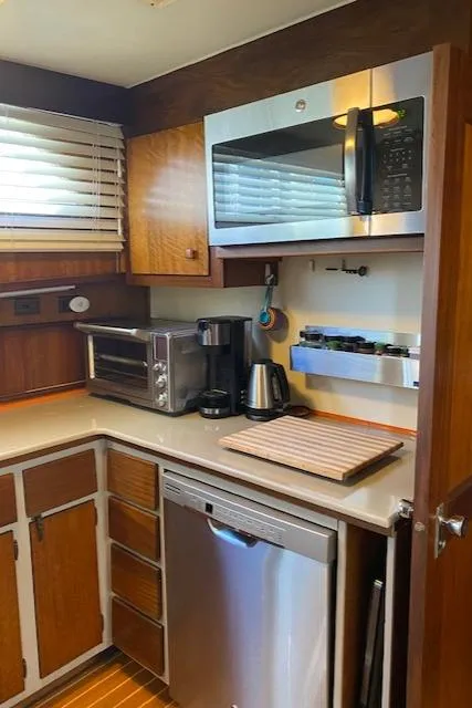 Slide: The Image of 1973 Hatteras Motor Yacht kitchen with modern appliances and wooden cabinetry. - 25