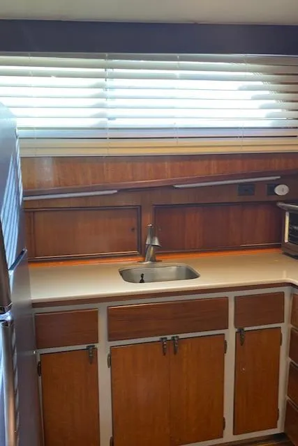 Slide: The Image of 1973 Hatteras Motor Yacht kitchen with wooden cabinets and stainless steel sink. - 26