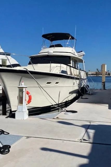 Slide: The Image of 1973 Hatteras Motor Yacht docked at marina under clear blue sky. - 3