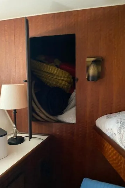 Slide: The Image of Interior of 1973 Hatteras Motor Yacht with open cabinet and cozy bedding. - 31