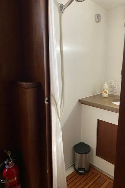 Slide: The Image of 1973 Hatteras Motor Yacht bathroom with shower, sink, and fire extinguisher. - 36