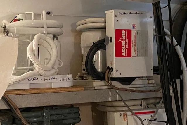 Slide: The Image of 1973 Hatteras Motor Yacht equipment room with Aquair systems and labeled components. - 43