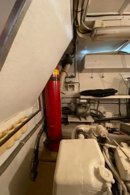 Slide: The Image of Engine room of 1973 Hatteras Motor Yacht with visible fire extinguisher and machinery. - 45