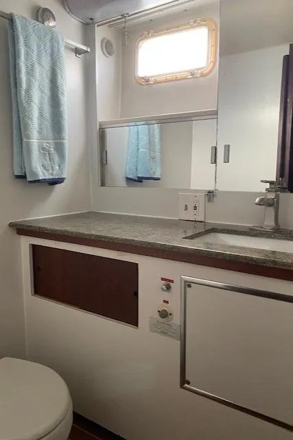 Slide: The Image of 1973 Hatteras Motor Yacht bathroom with sink, mirror, and towel. - 49