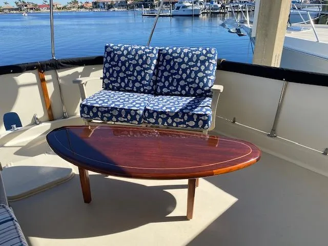 Slide: The Image of 1973 Hatteras Motor Yacht deck with blue cushioned seating and wooden table. - 6