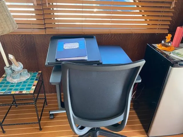 Slide: The Image of Office setup on 1973 Hatteras Motor Yacht with desk, chair, and mini fridge. - 7