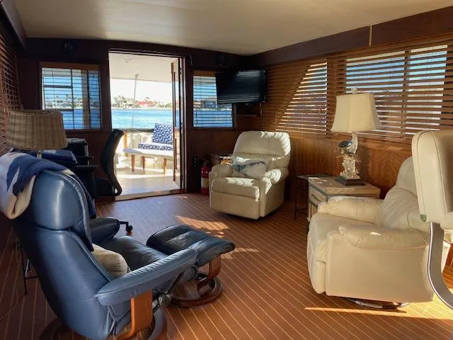 Slide: The Image of Interior of a 1973 Hatteras Motor Yacht with comfortable seating and wood paneling. - 8