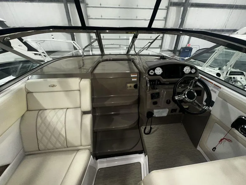 Slide: The Image of Interior of 2018 Regal 28 Express boat with beige seating and modern dashboard. - 1
