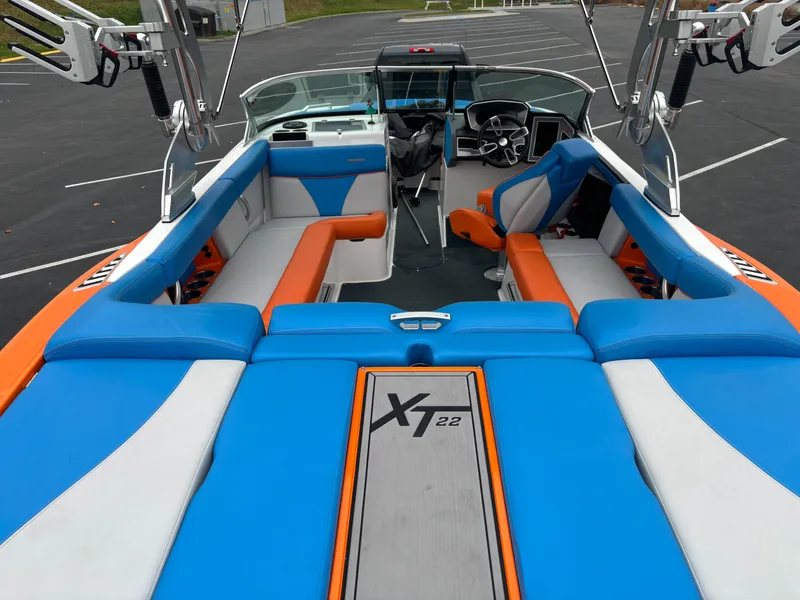 Slide: The Image of 2020 MasterCraft XT22 boat interior with vibrant blue and orange seating. - 1