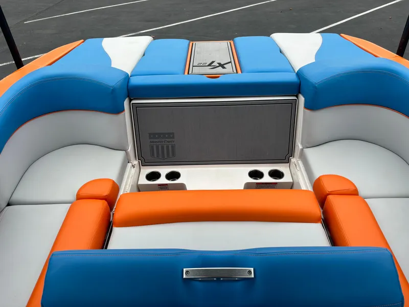 Slide: The Image of 2020 MasterCraft XT22 boat interior with vibrant orange, blue, and white seating. - 2