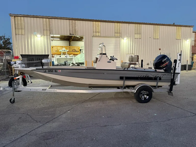 Slide: The Image of 2020 Xpress H20B boat on trailer outside a warehouse at dusk. - 11