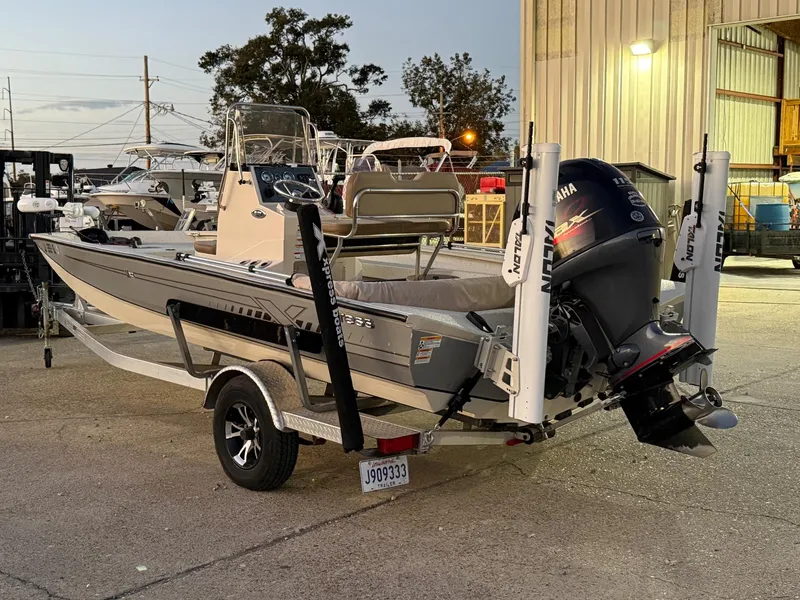 Slide: The Image of 2020 Xpress H20B boat with Yamaha motor, parked outdoors near a building. - 3