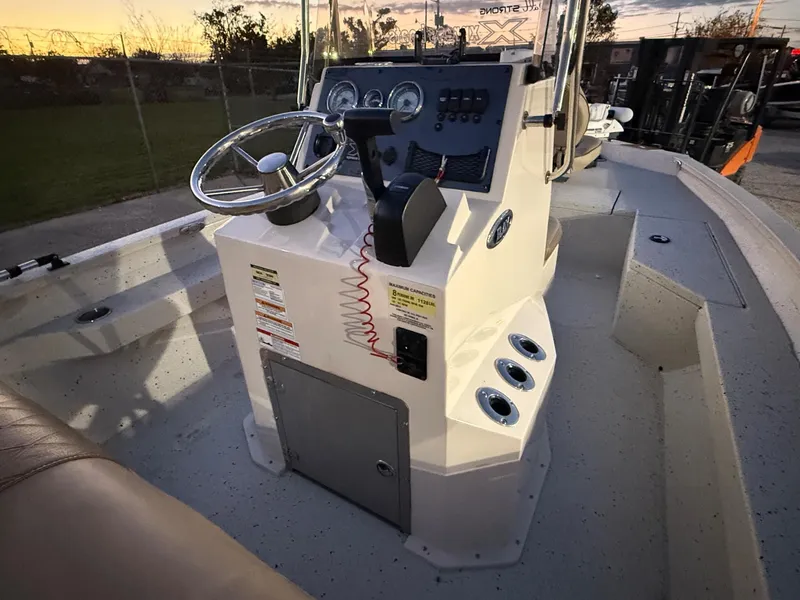 Slide: The Image of 2020 Xpress H20B boat console with steering wheel and controls at sunset. - 4